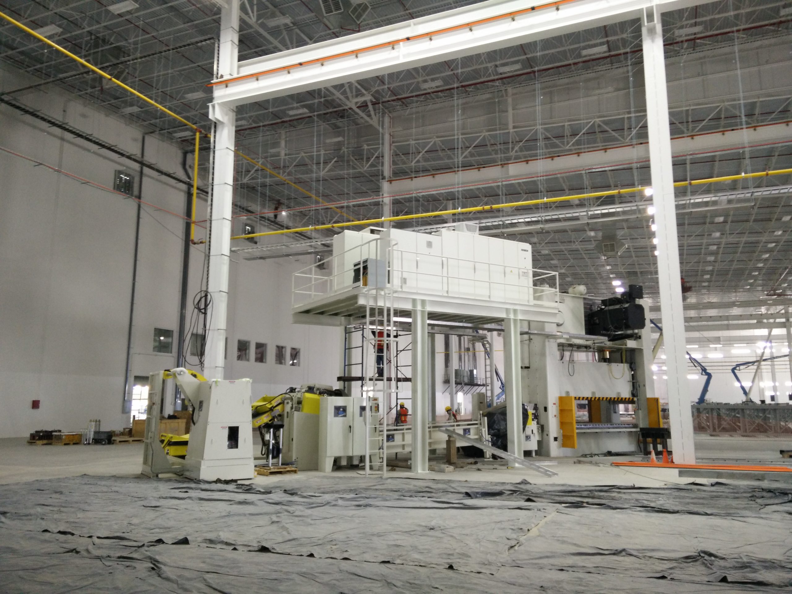 Mezzanine blanco con barandales y escalera en una nave industrial
